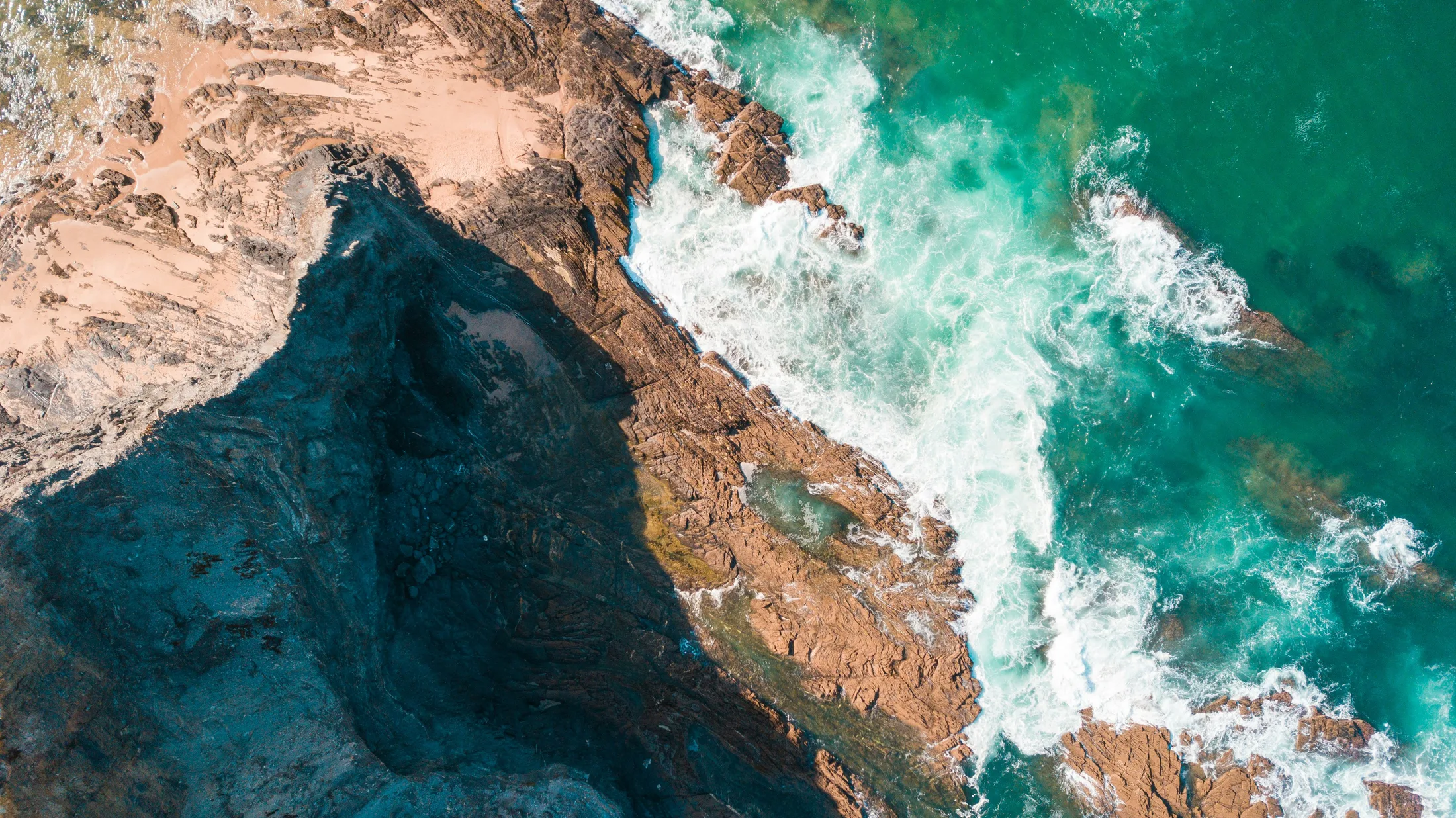 Aerial view of a rocky Atlantic coastline and clear ocean water